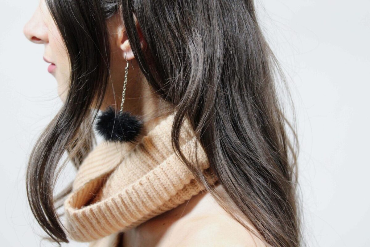 woman wearing black pompom earrings